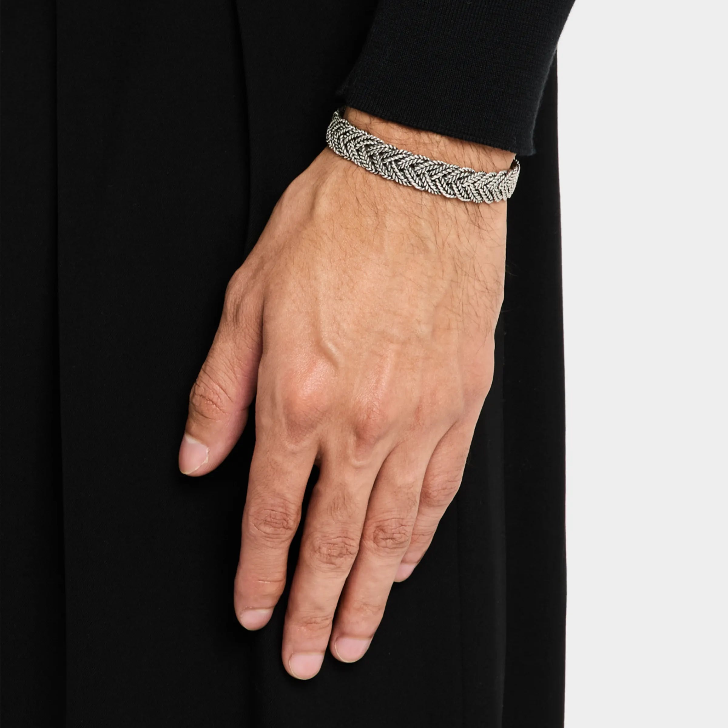 Man wearing oxidized sterling silver wide Balinese foxtail woven cuff bracelet on wrist close-up showing multi-strand braid texture and open cuff ends by Jan Leslie