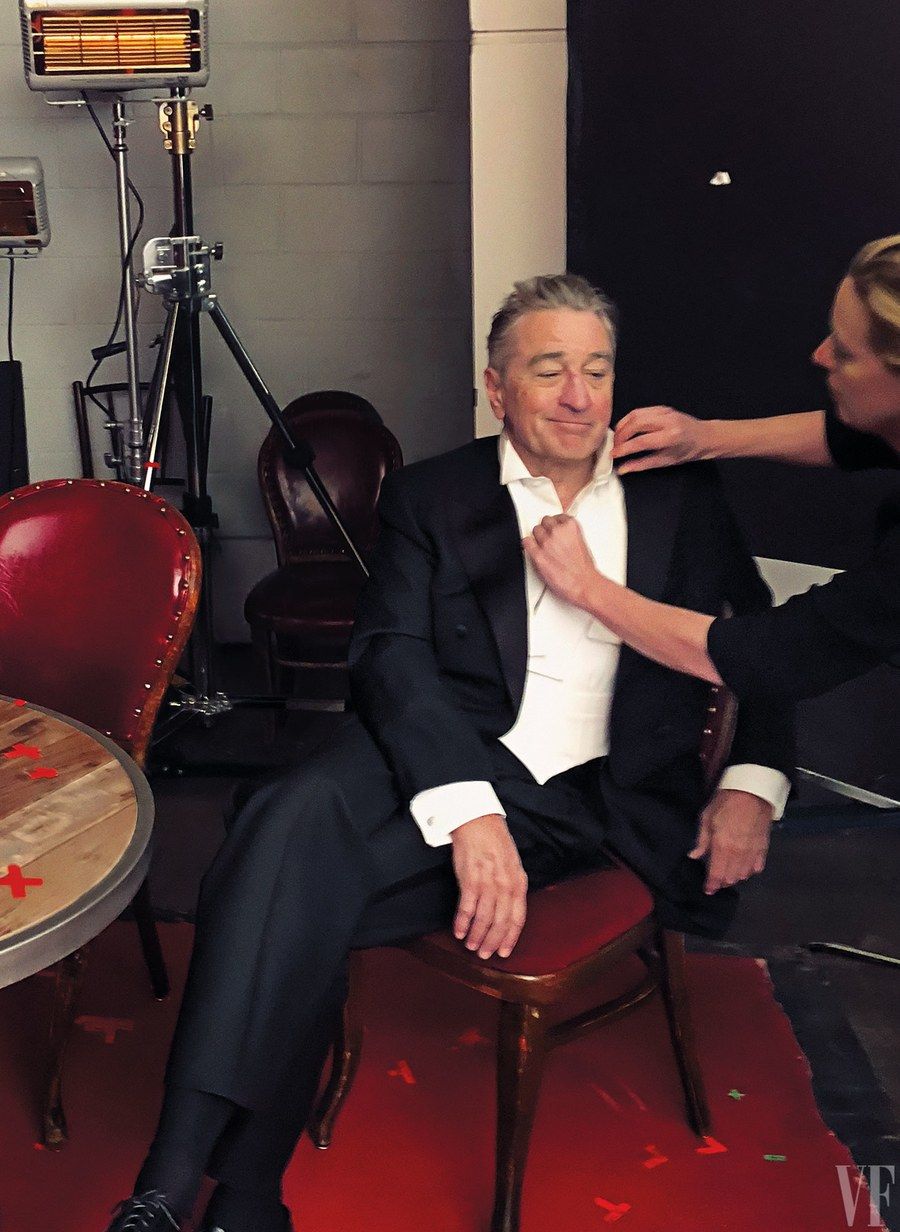Photo of behind the scenes at Vanity Fair. Robert DeNiro sits as he's being styled wearing a black tuxedo, white tuxedo shirt and Jan Leslie's Mother of Pearl Gemstone with Rivet Etch Detail Sterling Silver Cufflinks & Tuxedo Studs.