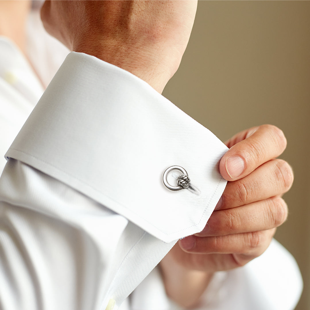 Man adjusting white French cuff dress shirt wearing sterling silver rope knot ring cufflink Jan Leslie