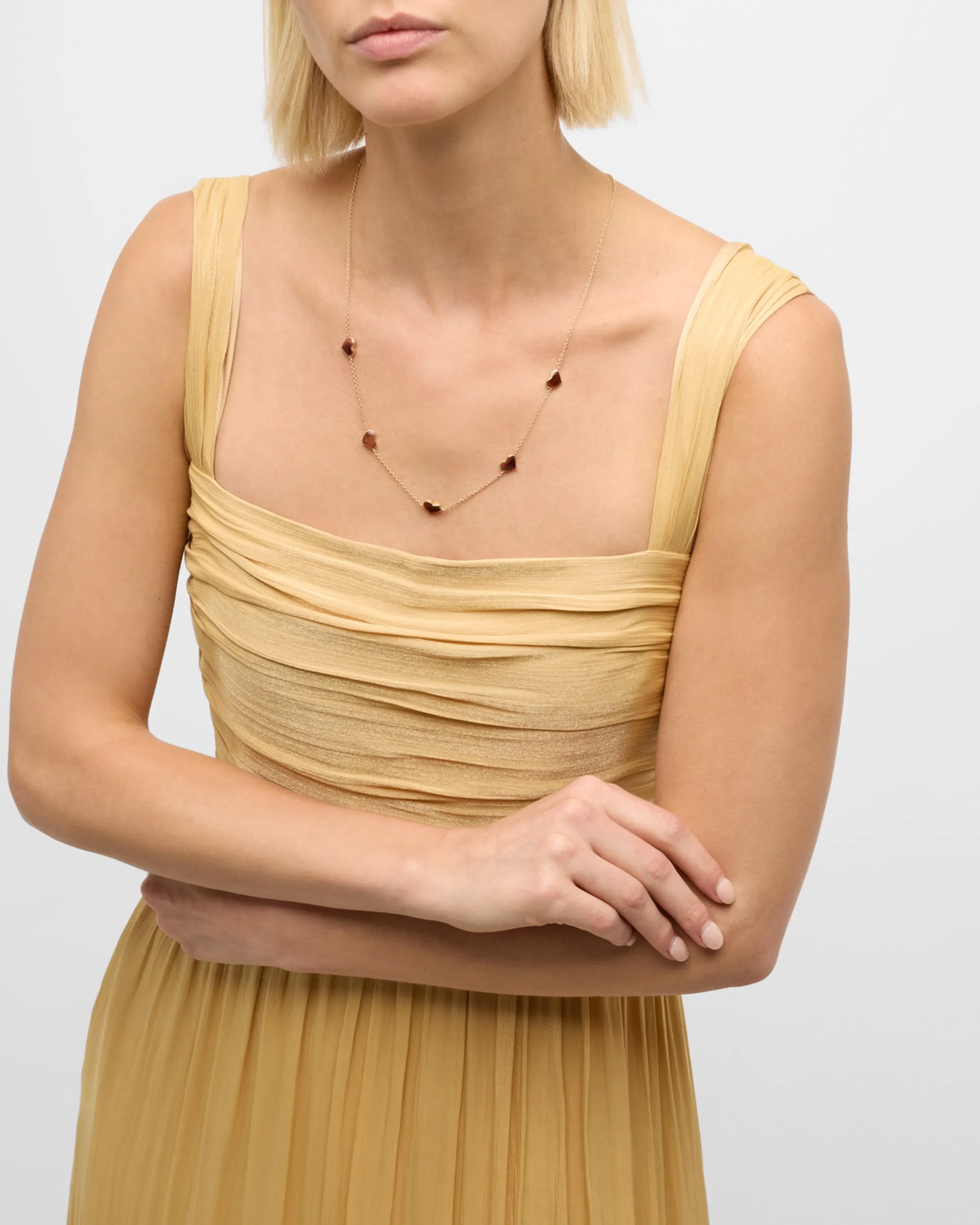 Model in gold dress wearing red tiger's eye five-heart station gold necklace — Jan Leslie