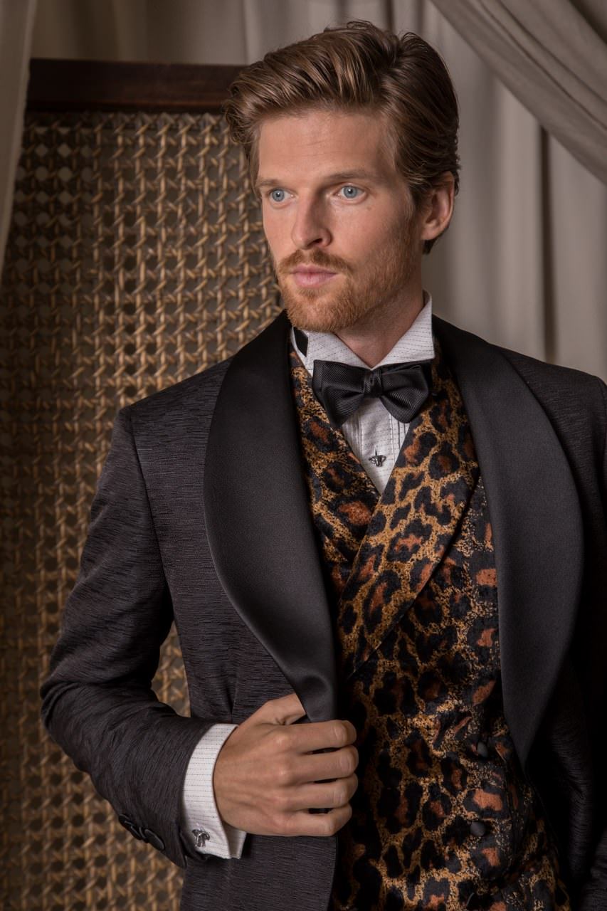 Male model wearing a black tuxedo jacket with satin lapels, leopard print vest , black bowtie and patterned shirt, with Jan Leslie Elephant Head Mother of Pearl & Enamel Sterling Silver Cufflinks & Tuxedo Studs
