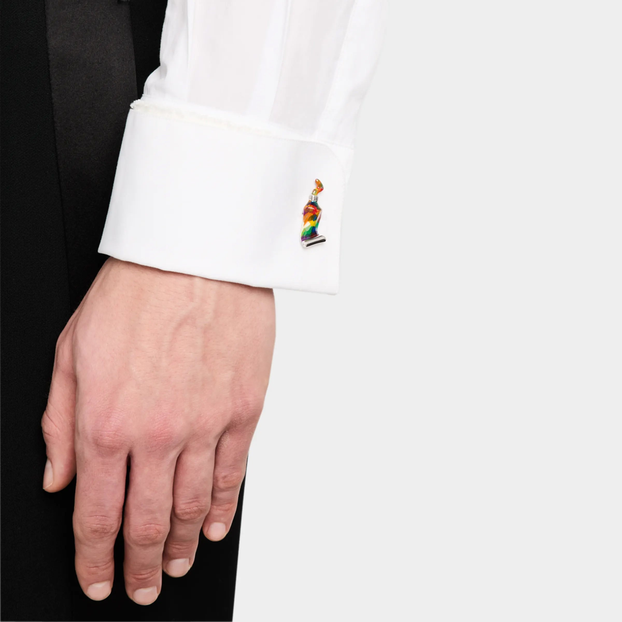 Man wearing sterling silver rainbow stripe resin paint tube cufflink on white French cuff with black tuxedo jacket close-up by Jan Leslie