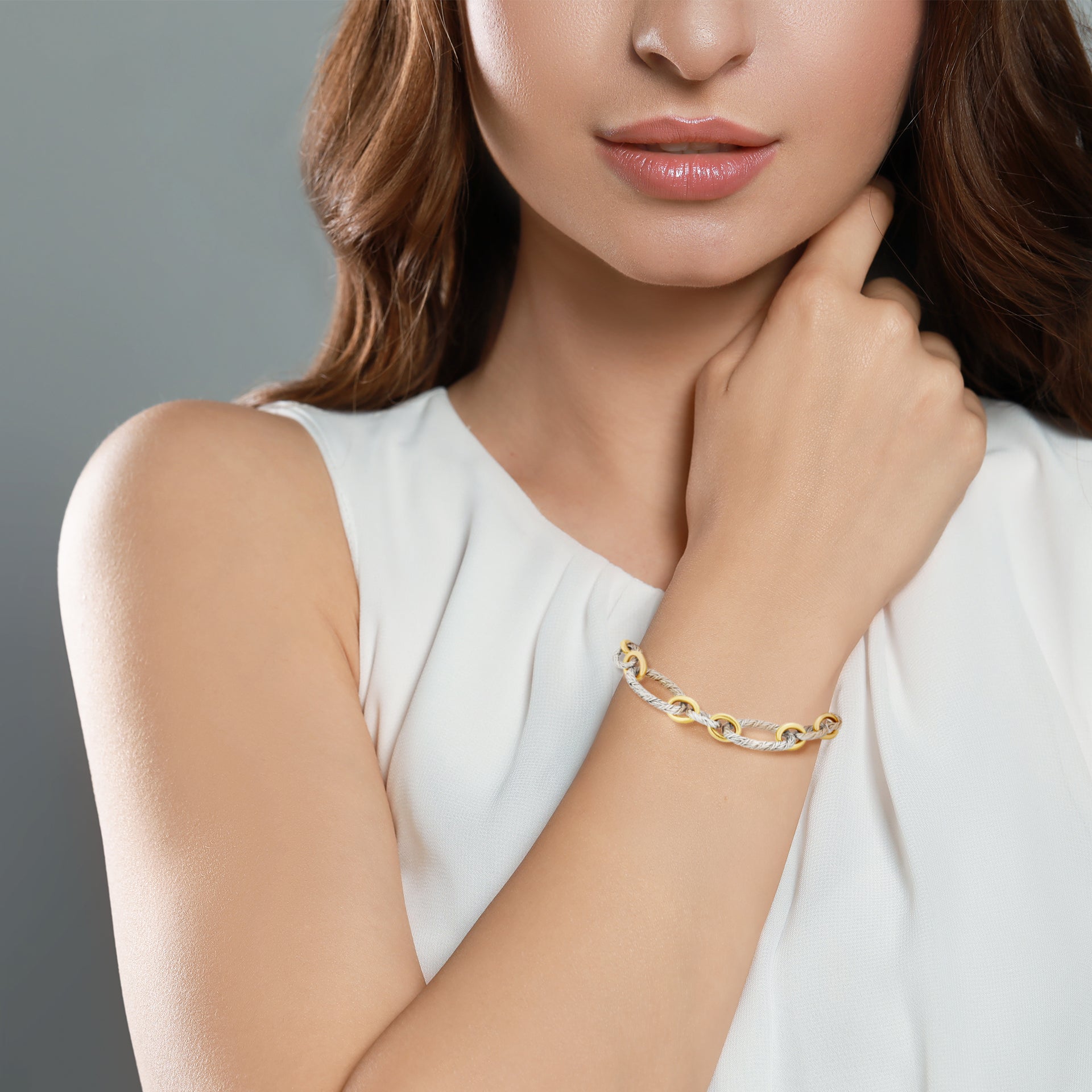 Two-tone rope-textured oval link bracelet in sterling silver with polished gold connectors, perfect for everyday luxury.