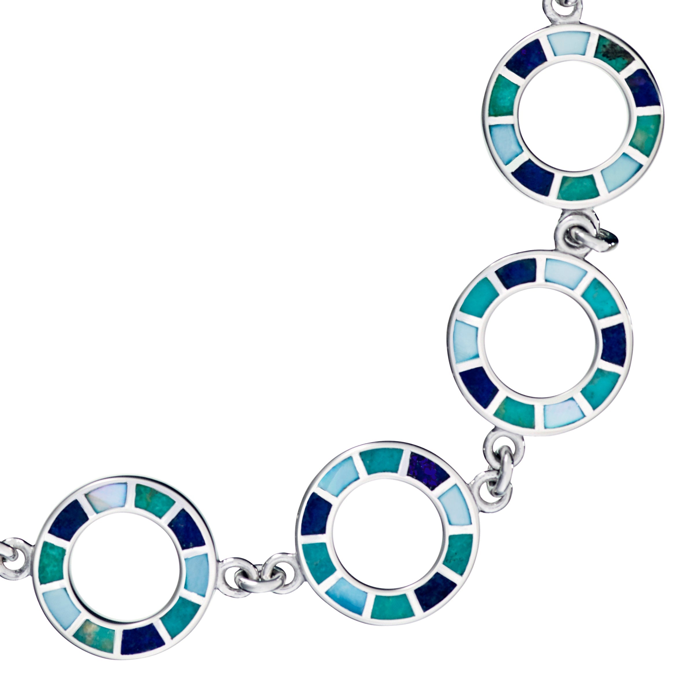 Close-up of sterling silver open circle links with cobalt teal and sky blue enamel mosaic tile segments by Jan Leslie.