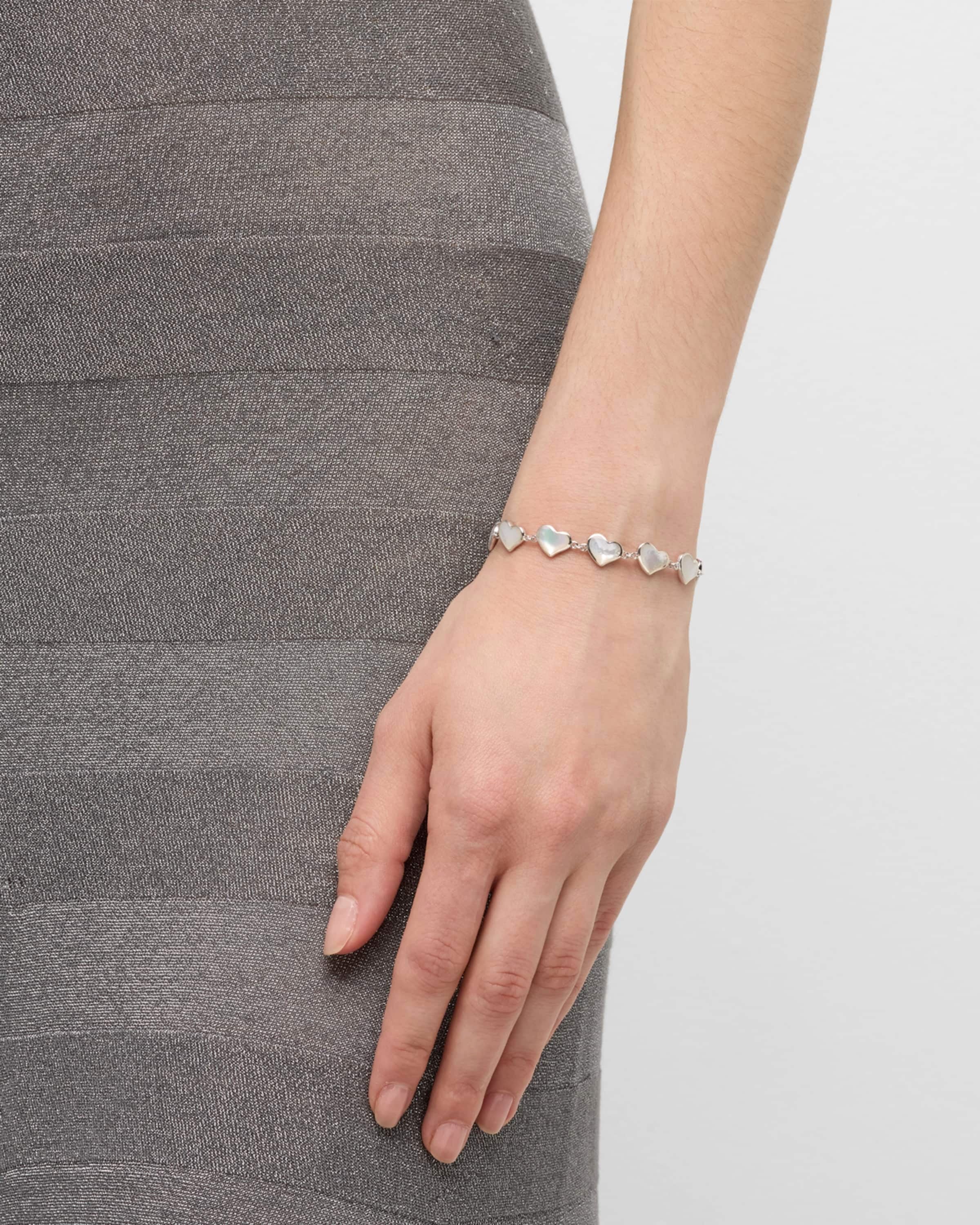 Model in grey skirt wearing white mother-of-pearl heart link sterling silver bracelet — Jan Leslie