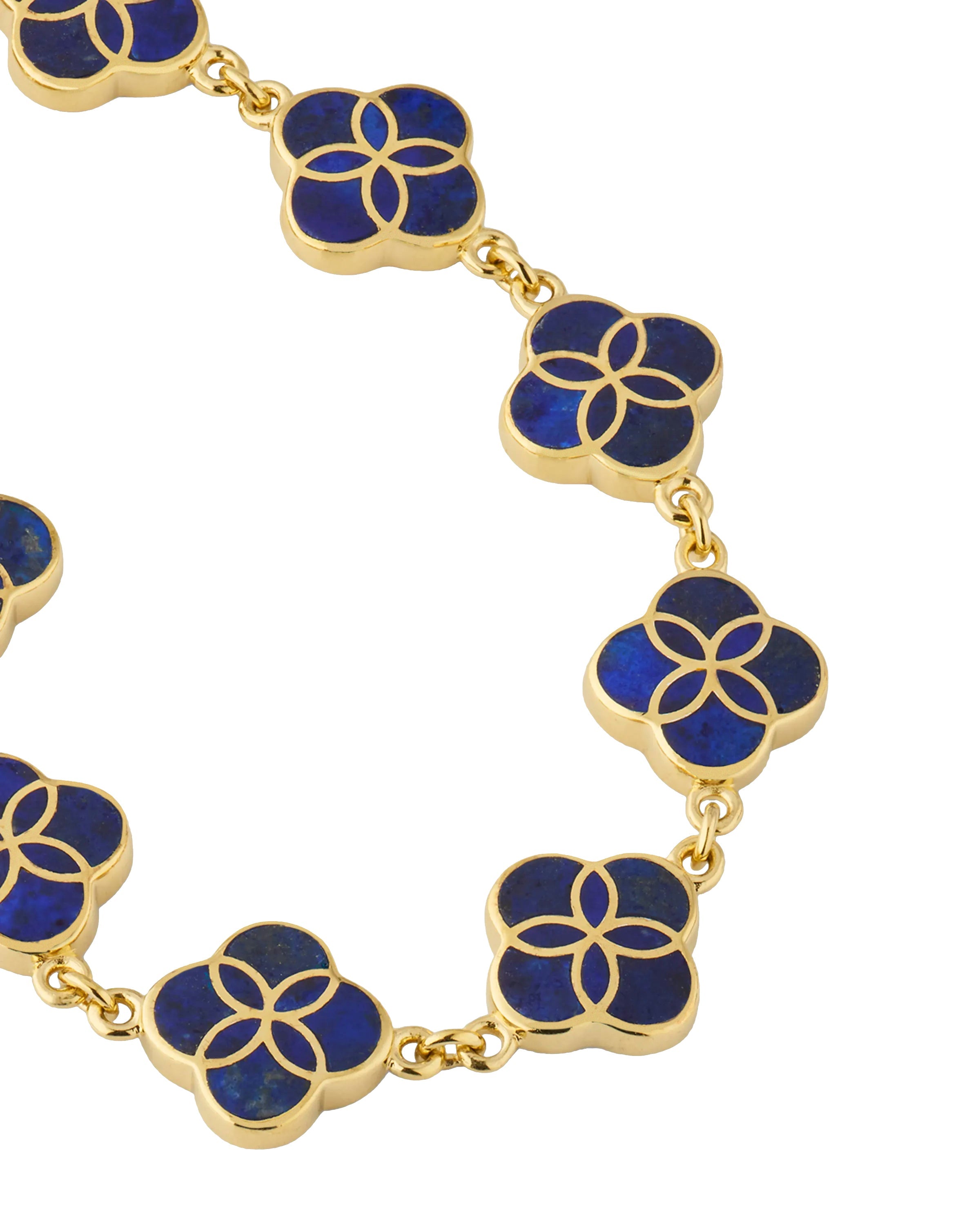 Close-up macro detail of gold vermeil sterling silver multi-station lapis lazuli floral lattice quatrefoil bracelet showing deep royal blue stone inlay with gold curved petal overlay on bezel-set stations and rolo chain links, Jan Leslie