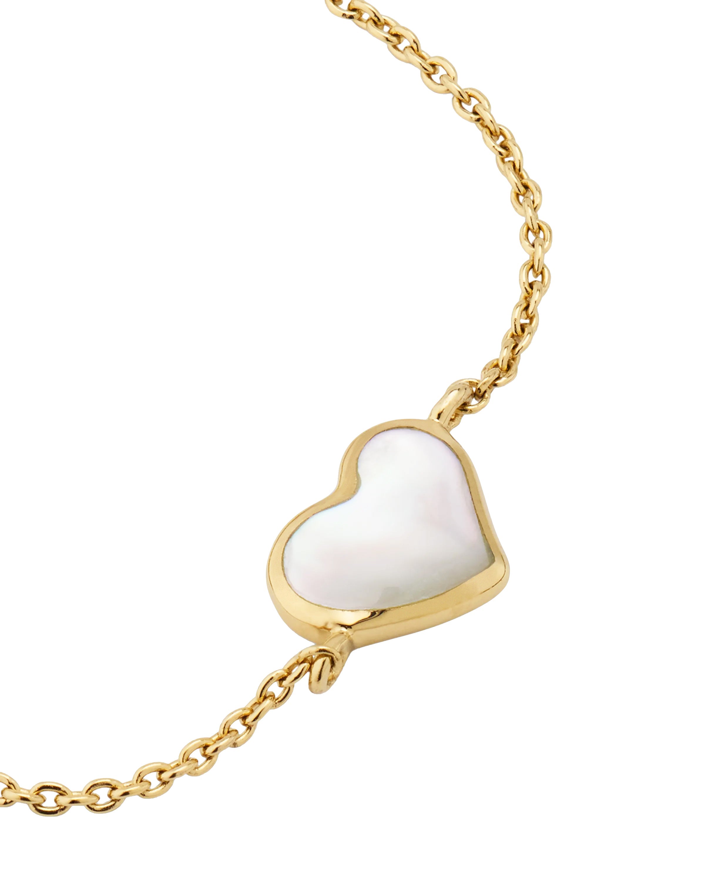 Close-up of white mother-of-pearl heart bezel pendant on gold cable chain — Jan Leslie