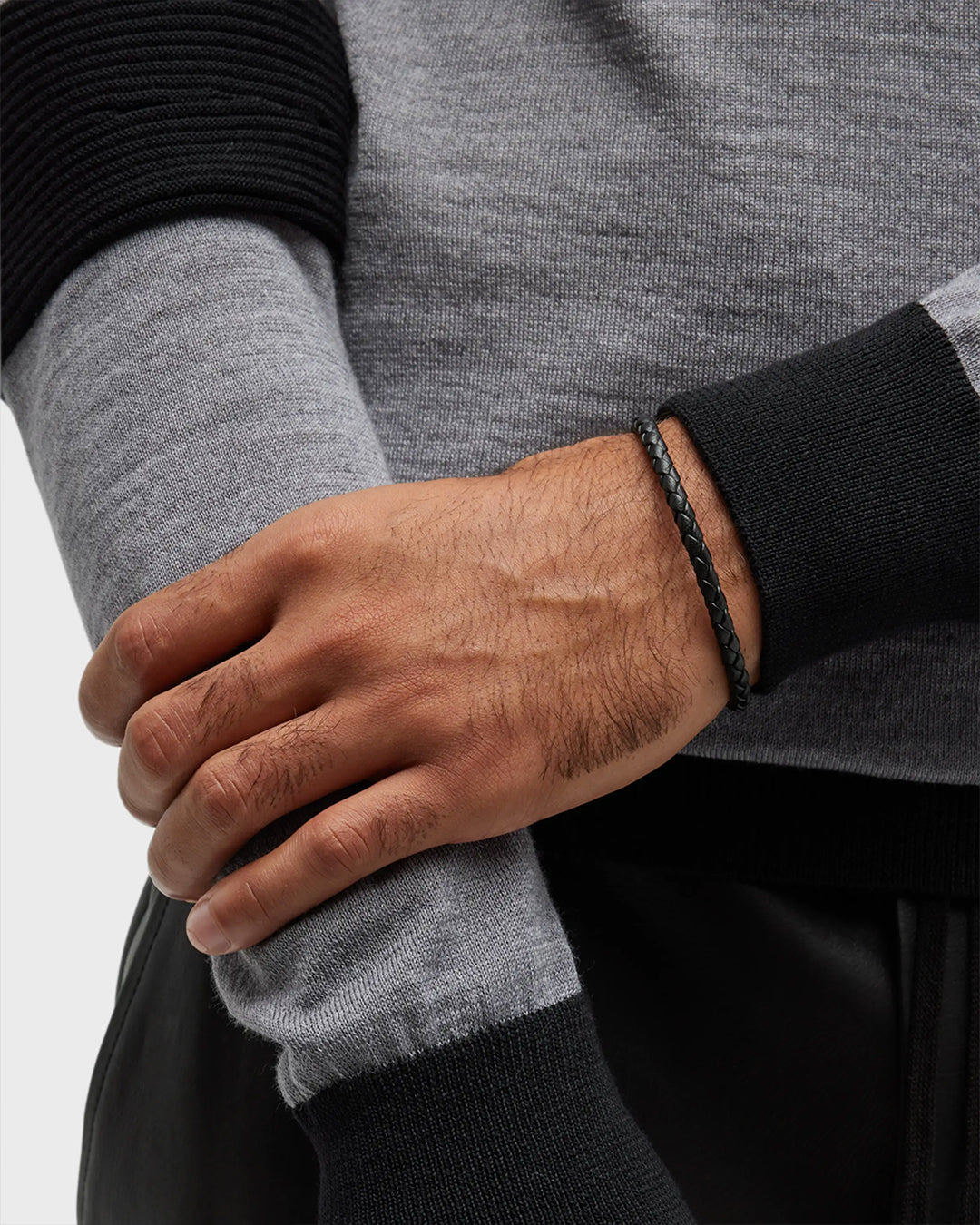 Black braided leather bracelet with magnetic clasp worn on man's wrist 