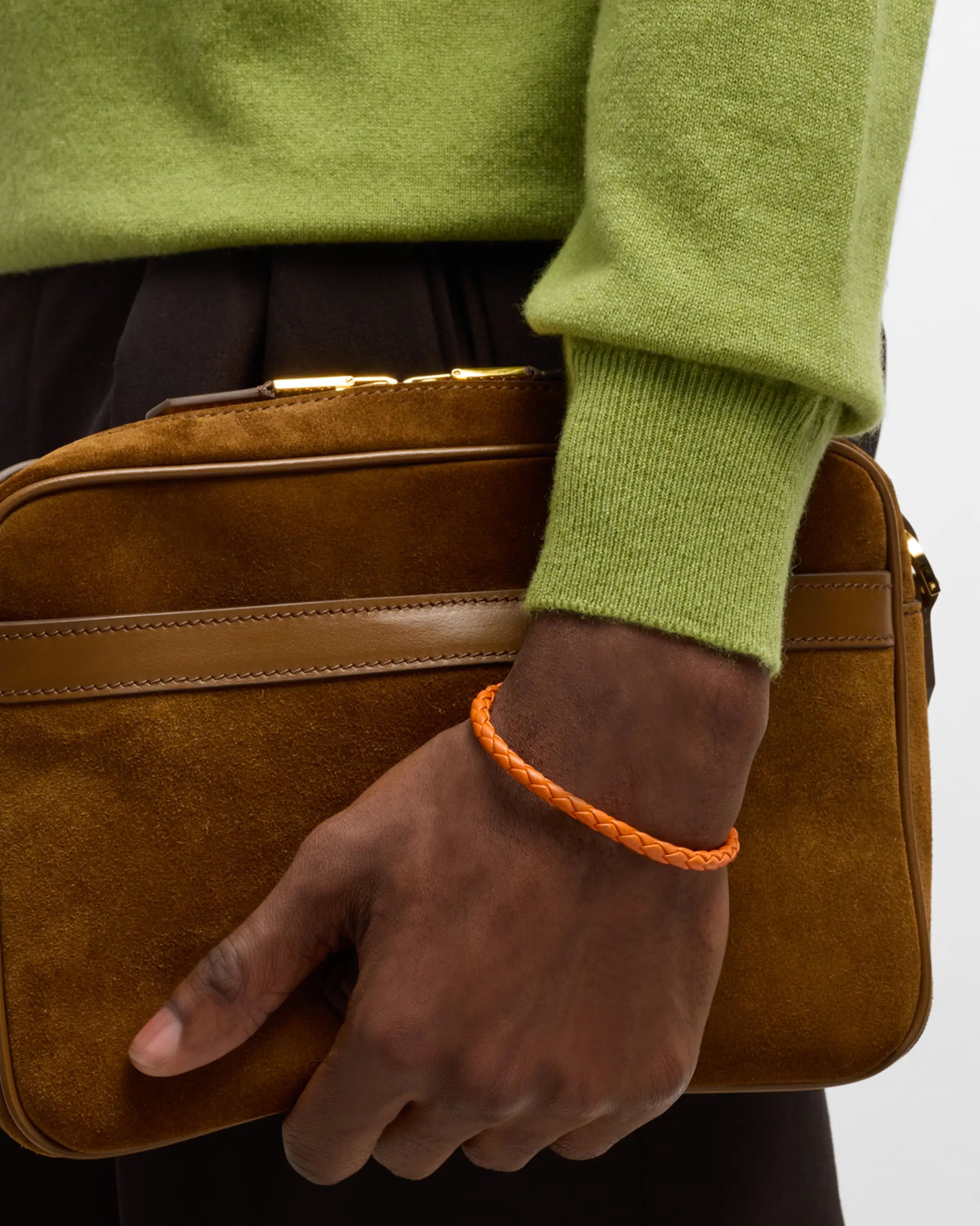 Orange braided leather bracelet with magnetic clasp worn on man's wrist 