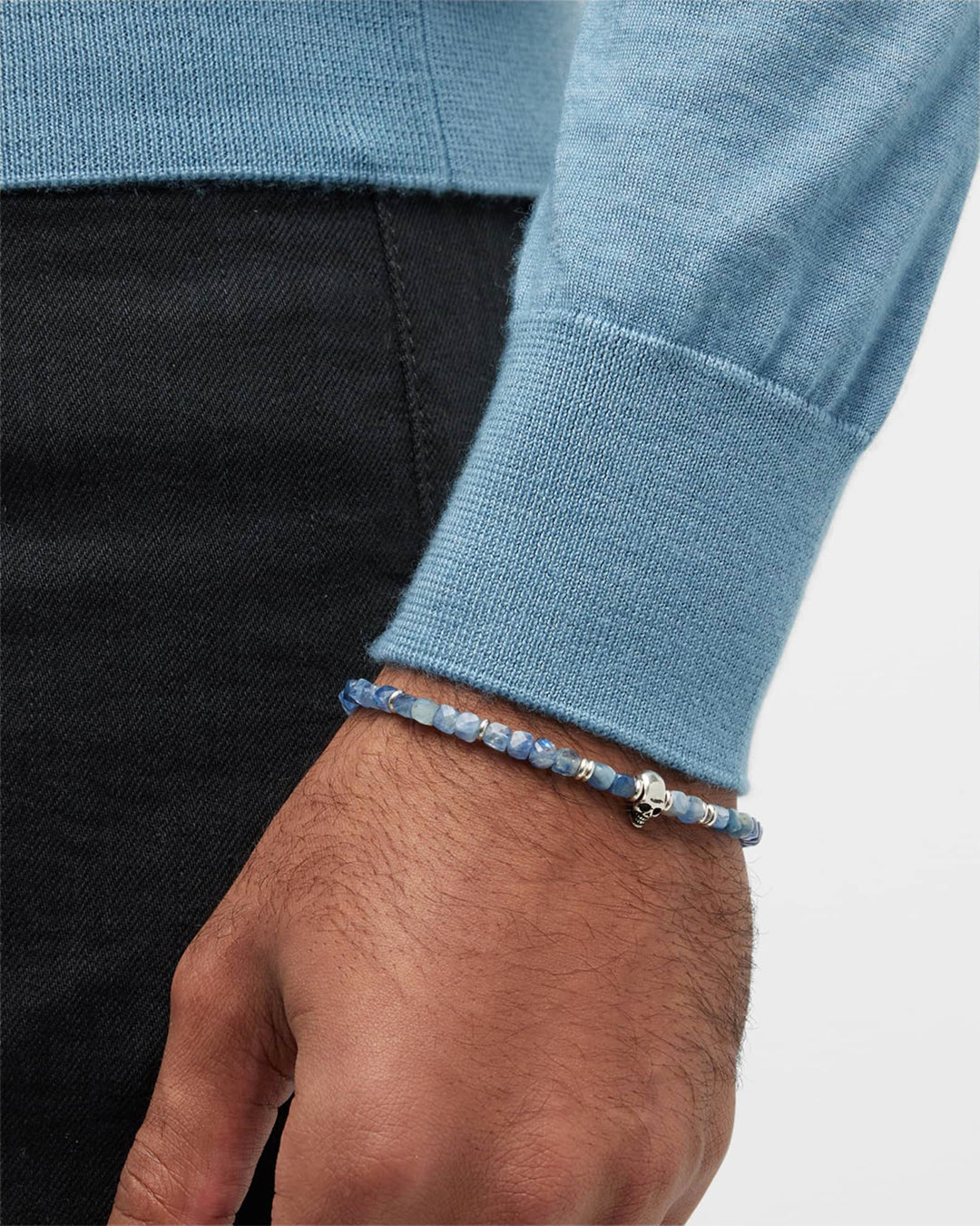 Close up of male models wrist donning the Faceted Kyanite Gemstone Skull Beaded Bracelet. 
