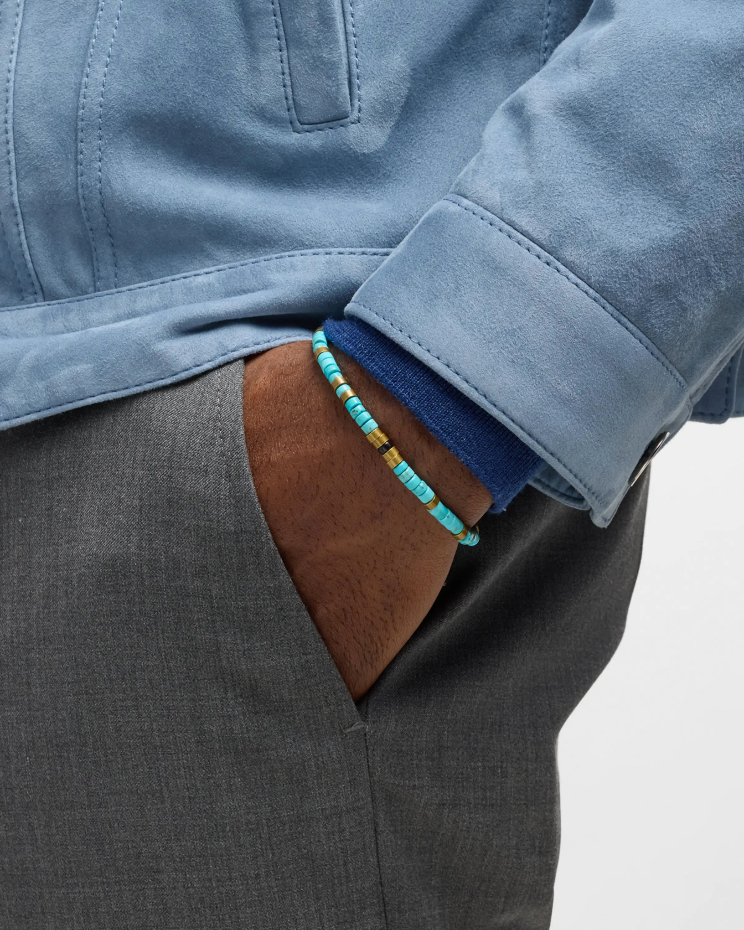 Men's turquoise heishi bead bracelet with brass spacers styled with blue suede jacket and grey trousers, Jan Leslie