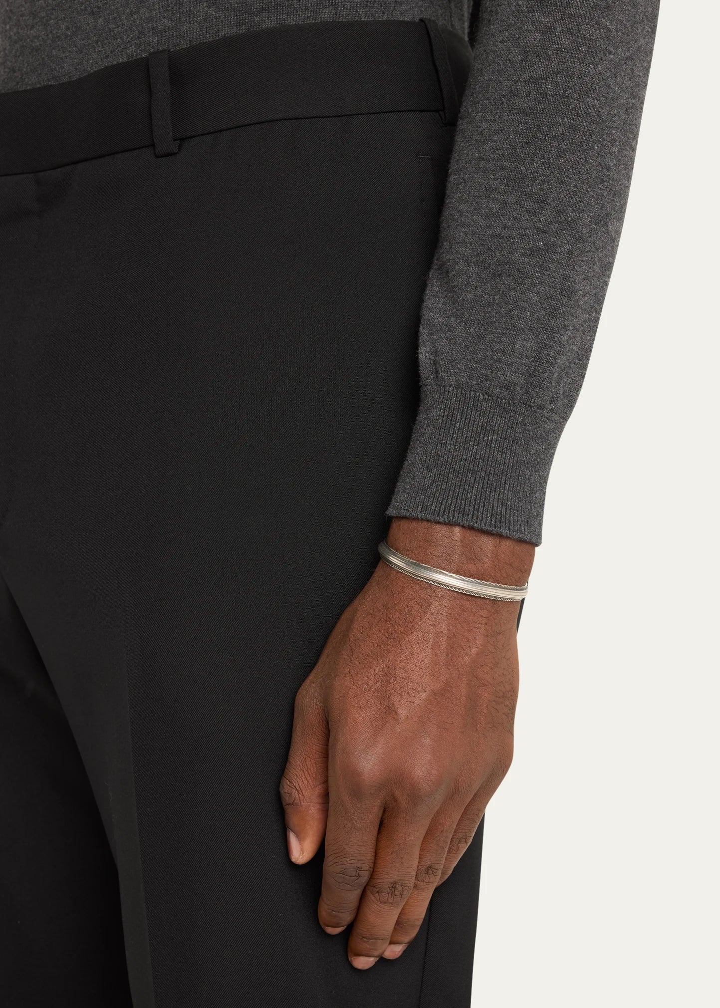 Man wearing sterling silver oxidized rope-edge triple-channel open cuff bracelet on wrist with grey merino sweater and black trousers by Jan Leslie