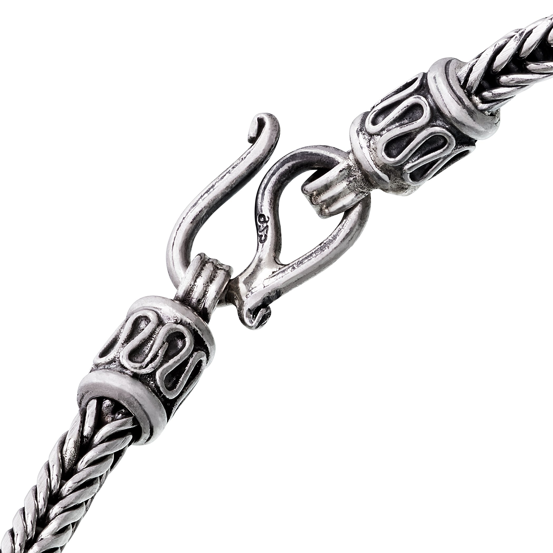 Close-up of oxidized sterling silver braided wheat chain bracelet showing decorative end caps and hook clasp with 925 hallmark by Jan Leslie.