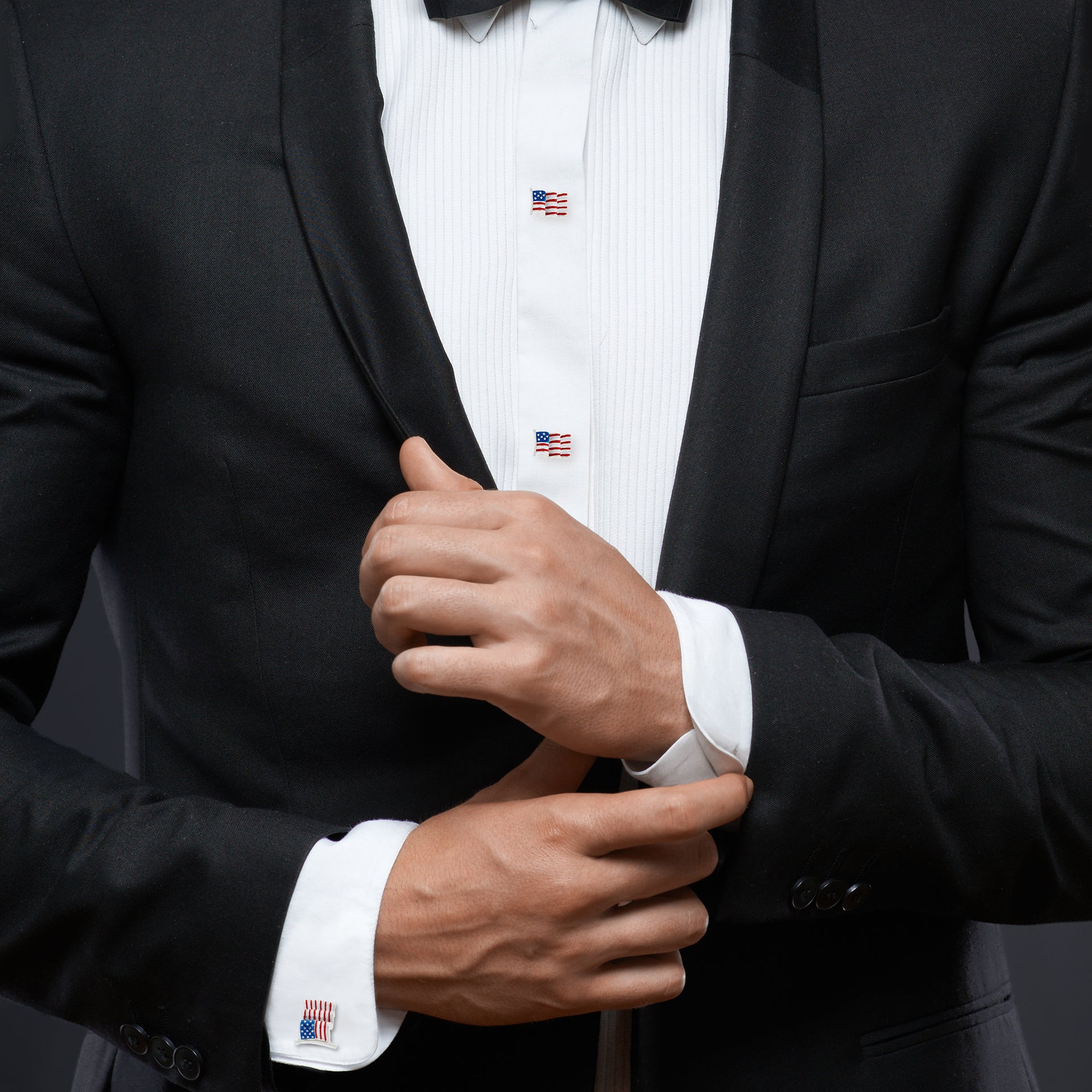 Man in black tuxedo wearing enamel American flag cufflinks and matching tuxedo studs on dress shirt by Jan Leslie.