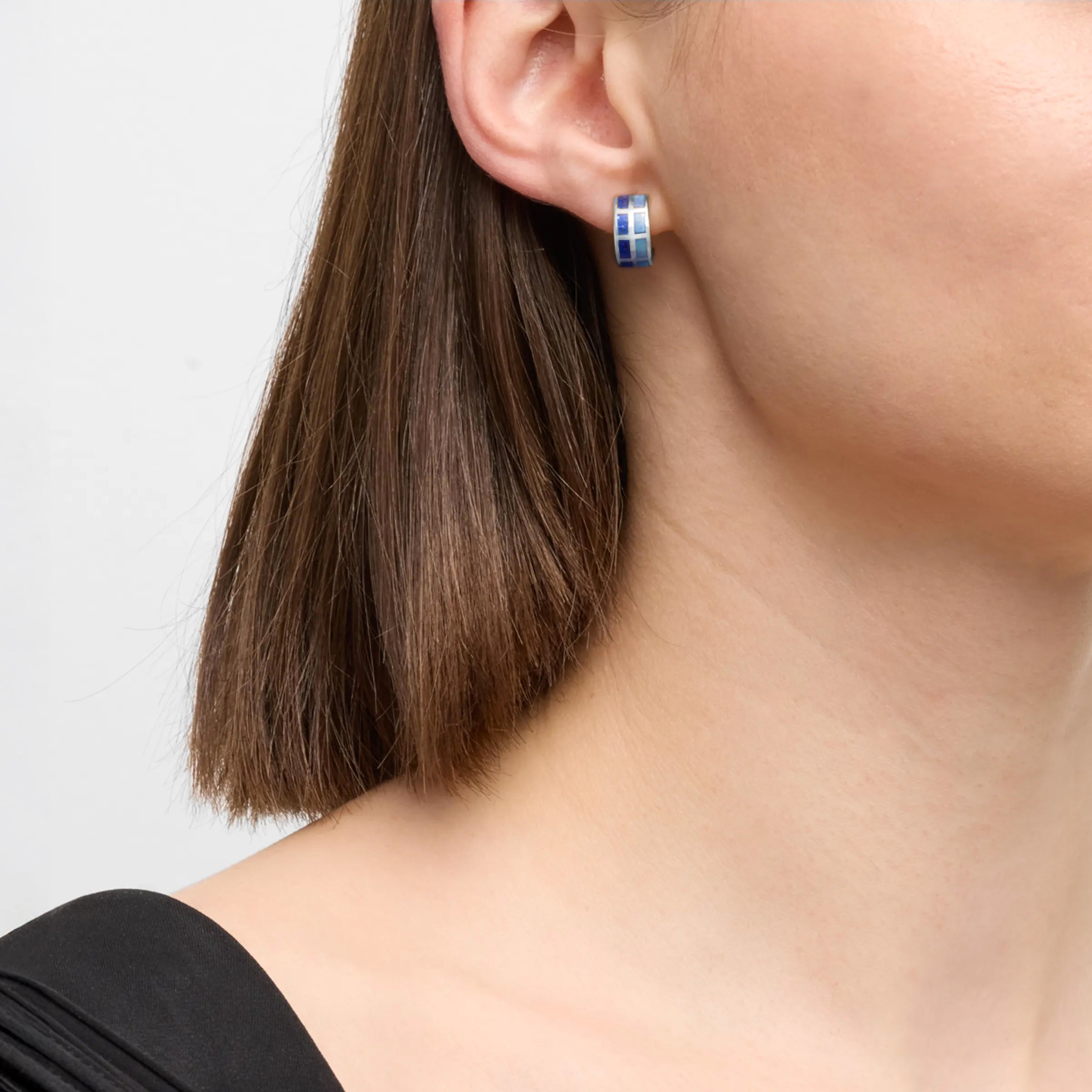 Model wearing sterling silver lapis lazuli and blue mother-of-pearl mosaic rectangle earrings with black top by Jan Leslie.