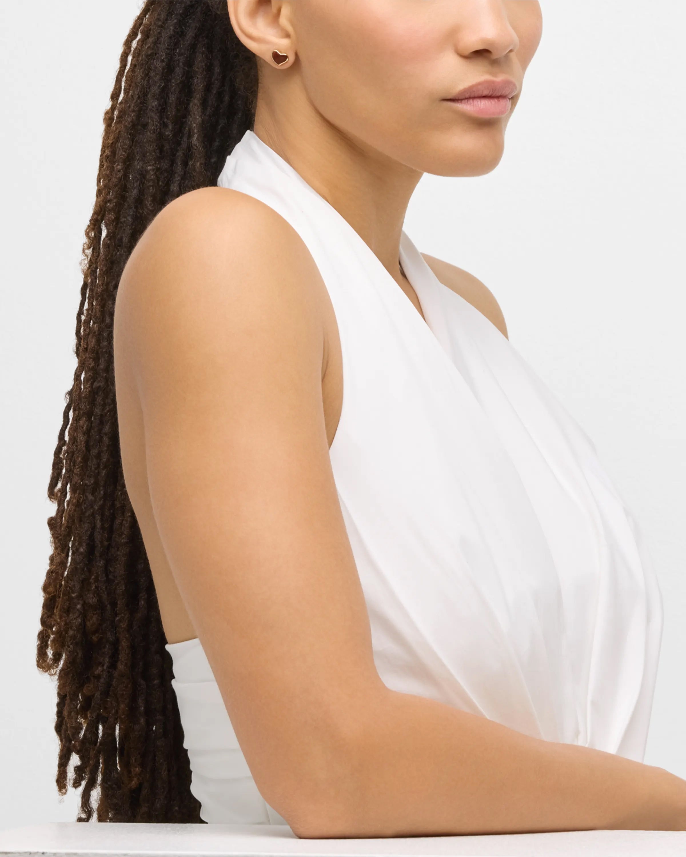 Model in white top wearing tiger's eye heart inlay gold stud earring — Jan Leslie