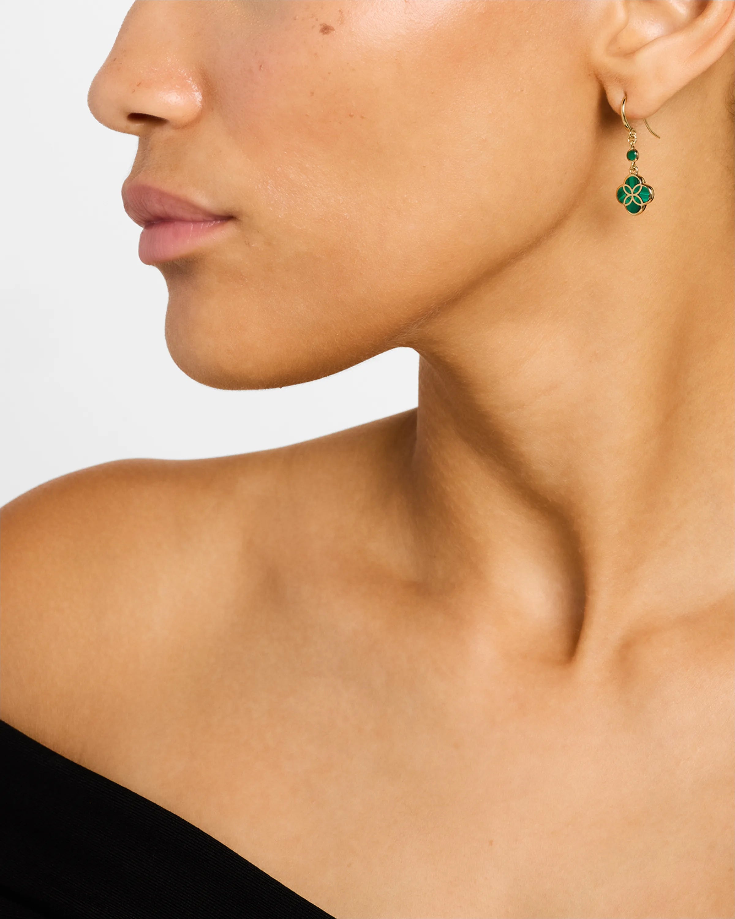 Woman wearing 18K gold vermeil malachite petal Seed of Life drop earrings showing deep forest green malachite quatrefoil clover pendant with Seed of Life gold lattice and small round malachite accent stone by Jan Leslie
