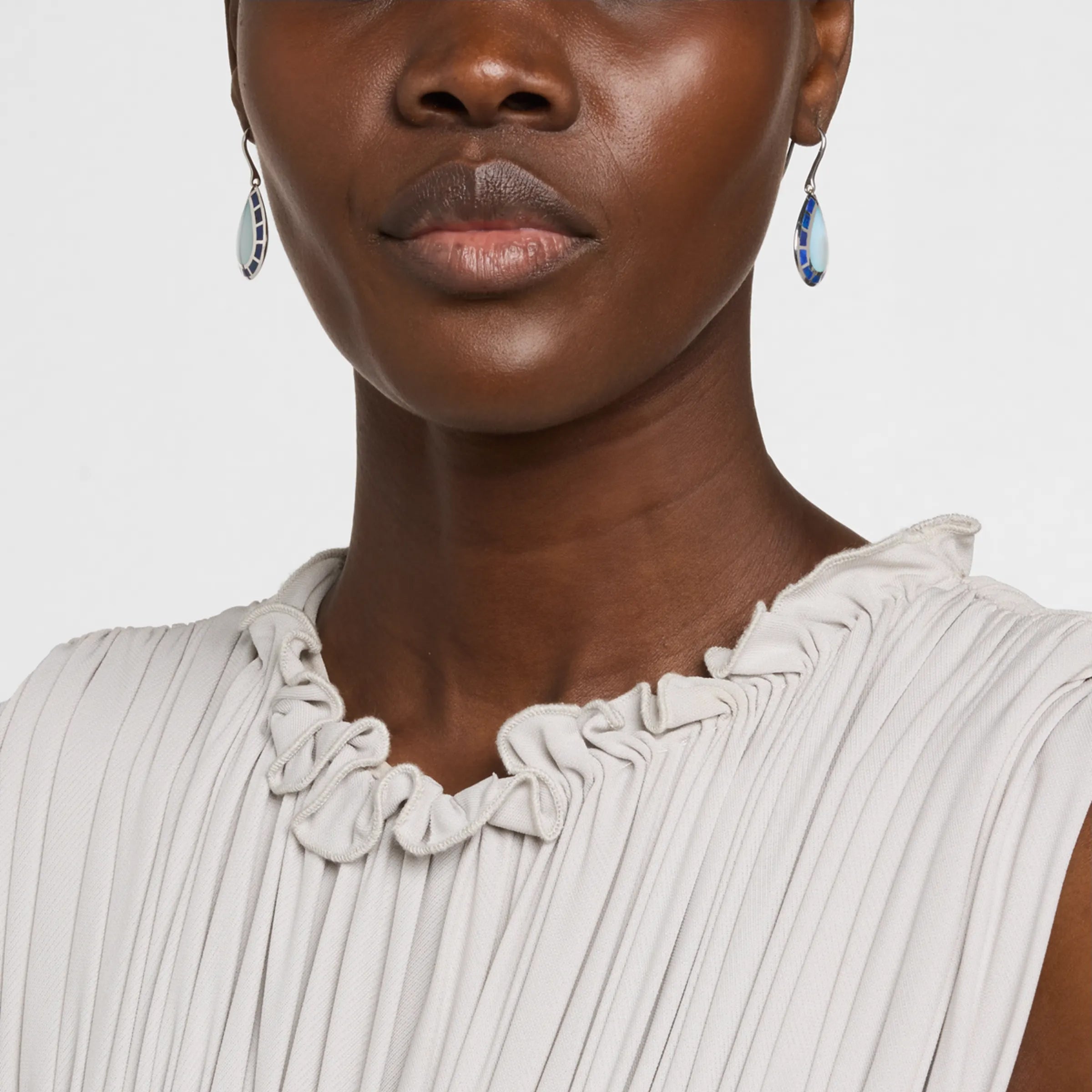 Model wearing sterling silver teardrop blue chalcedony and cobalt enamel drop earrings by Jan Leslie.
