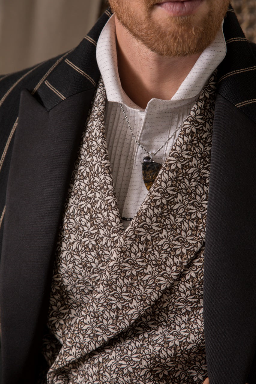 Close up of male models neck wearing the Small Petrified Wood Fossil One-of-a-Kind Arrow Pendant Sterling Silver Necklace by Jan Leslie. 