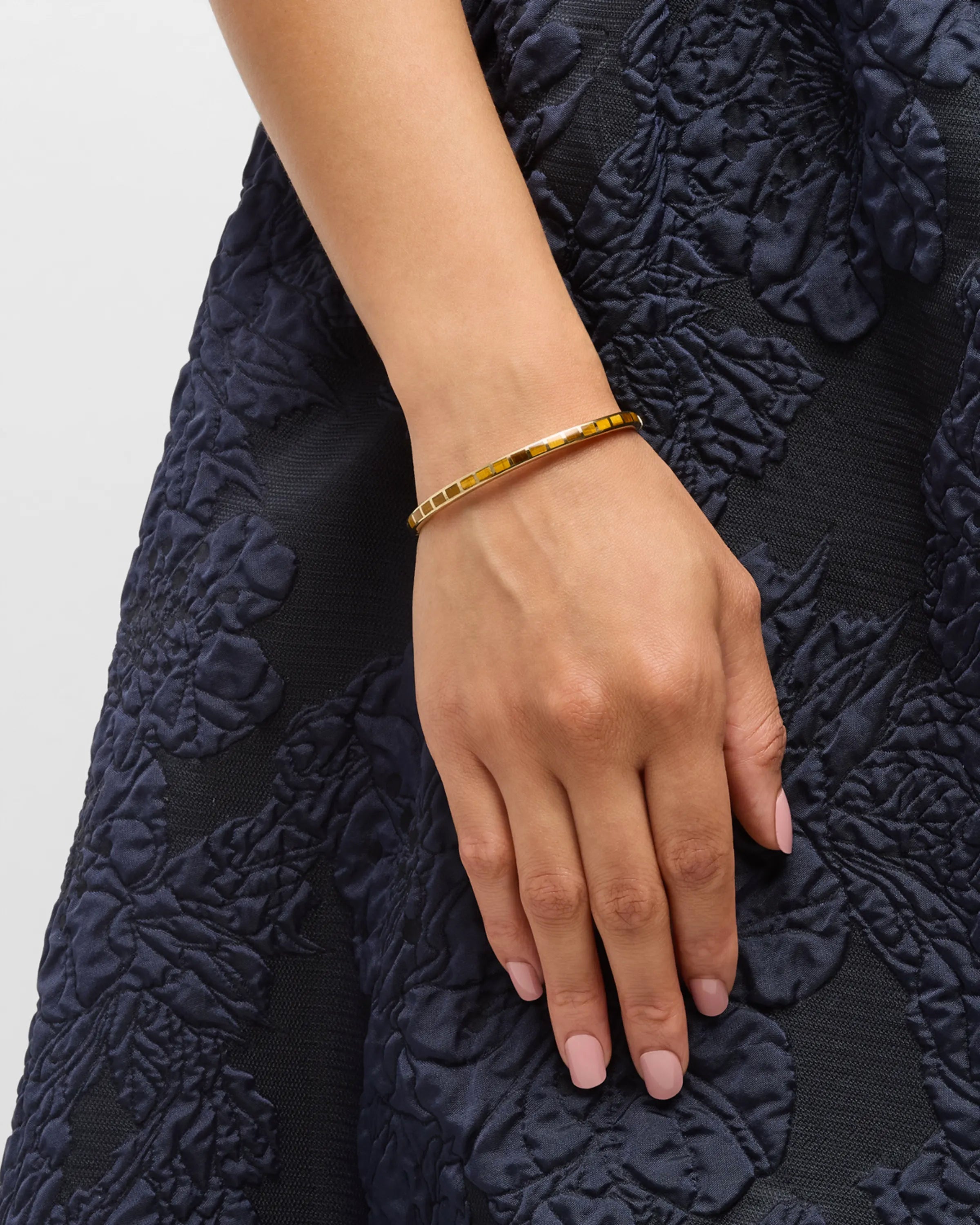Channel-set gemstone gold vermeil bangle bracelet stacked on model's wrist