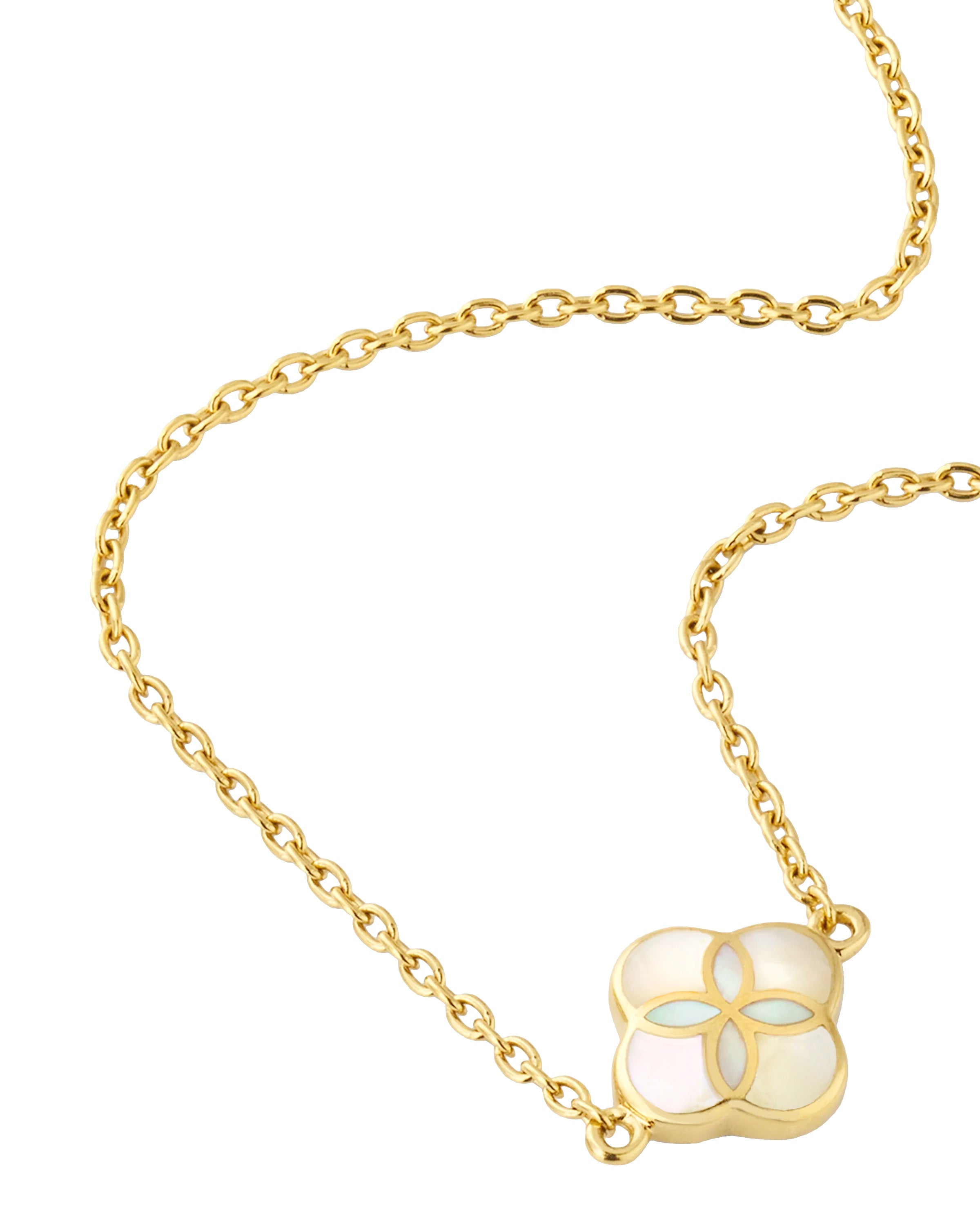 Close-up of white mother-of-pearl quatrefoil inlay gold pendant necklace — Jan Leslie