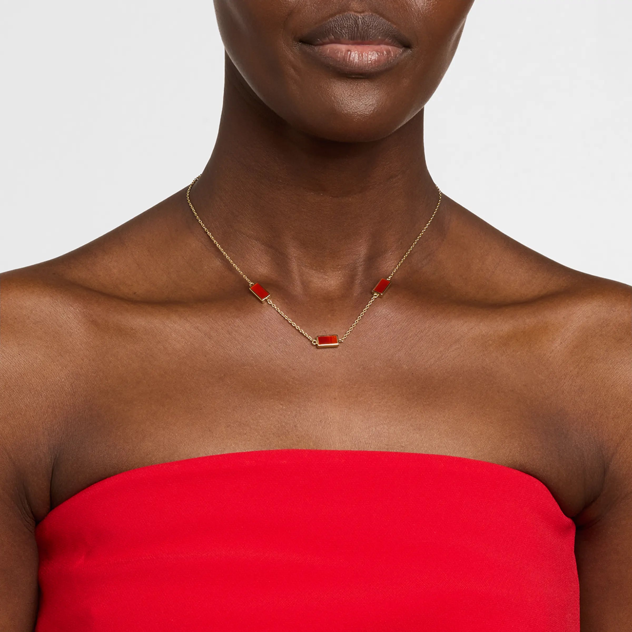  Model wearing gold vermeil four-station rectangular carnelian necklace on red strapless top by Jan Leslie.