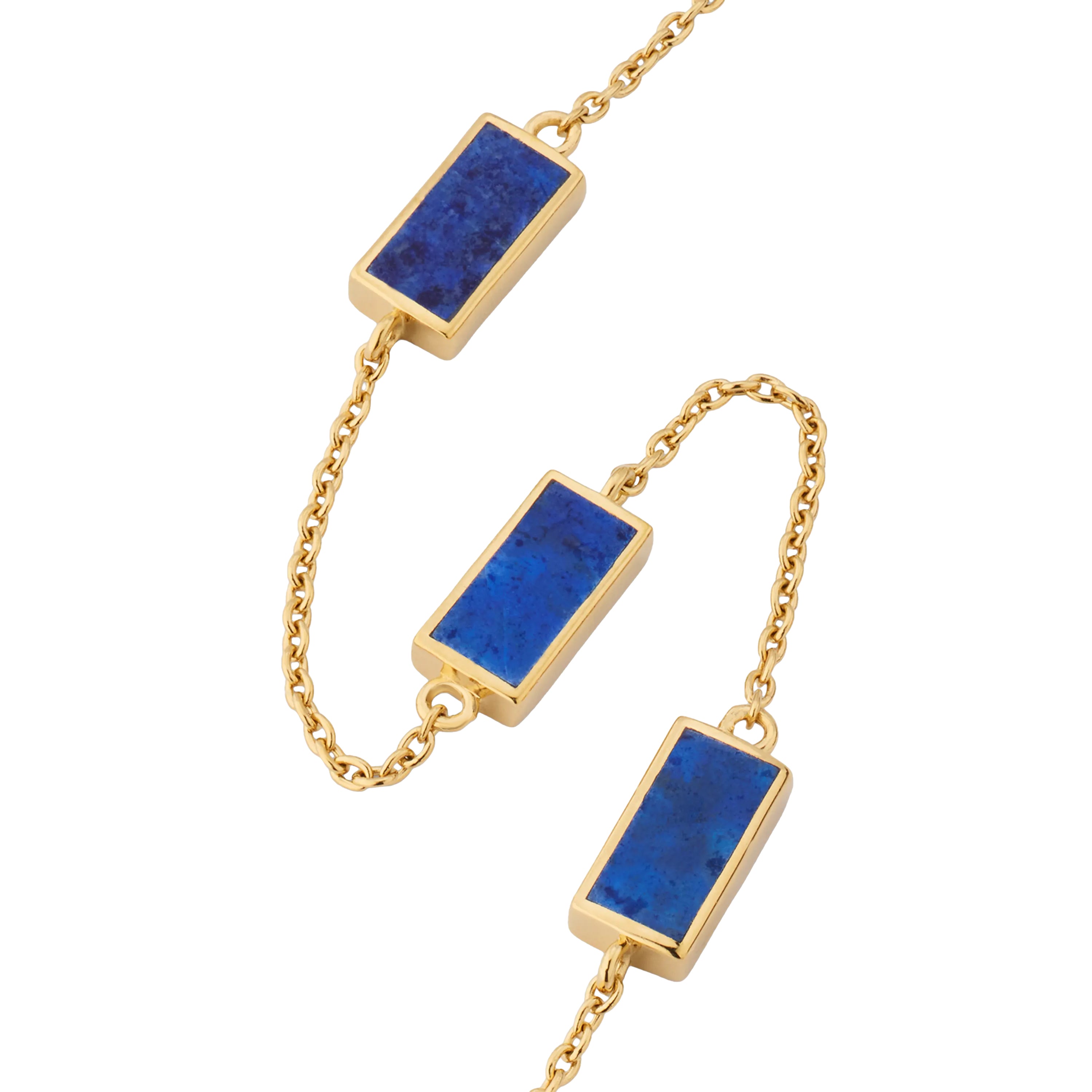 Close-up of three rectangular lapis lazuli stones with gold pyrite flecks in polished gold bezel settings on cable chain.