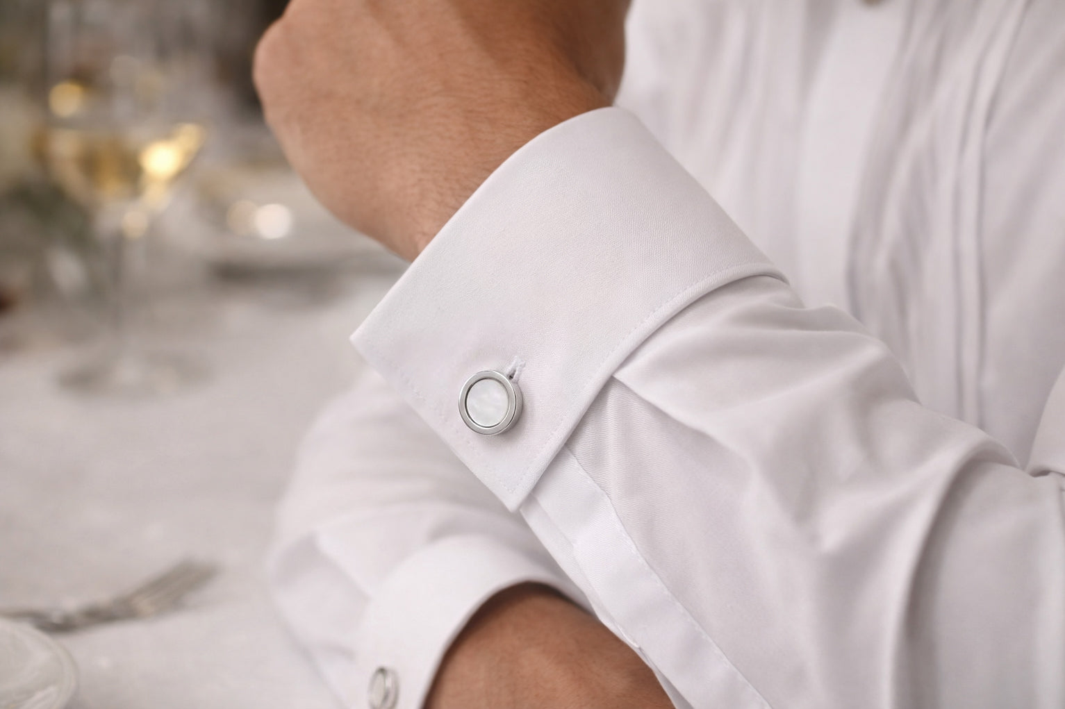 Sterling silver round mother-of-pearl cufflinks worn on white French cuff at formal dinner setting, Jan Leslie