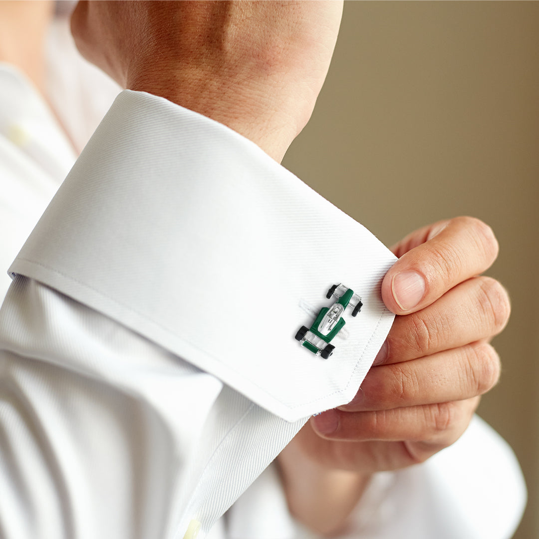 Man in white French cuff dress shirt with hands clasped wearing sterling silver and British racing green enamel Formula 1 racing car cufflink on cuff, Jan Leslie