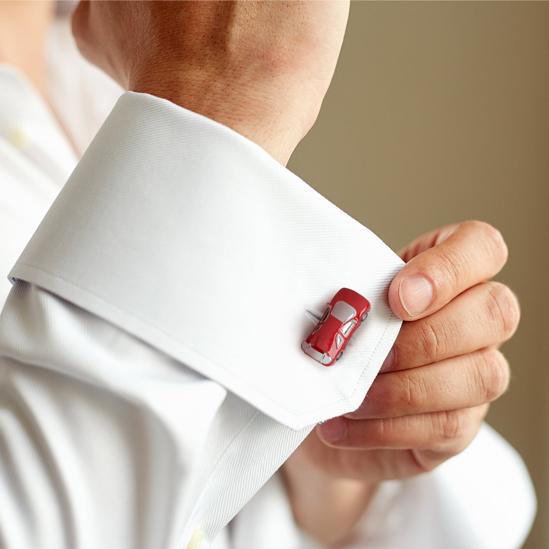 Man adjusting white French cuff dress shirt wearing sterling silver and red enamel sports car cufflink on cuff, Jan Leslie.