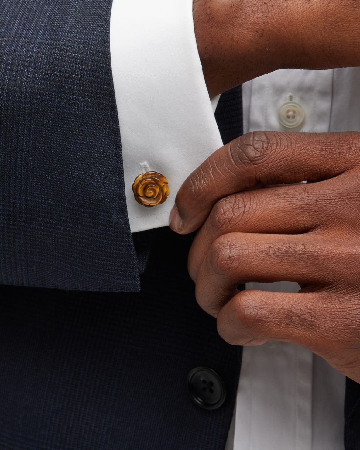 Man in tuxedo wearing tiger's eye carved rose cufflinks